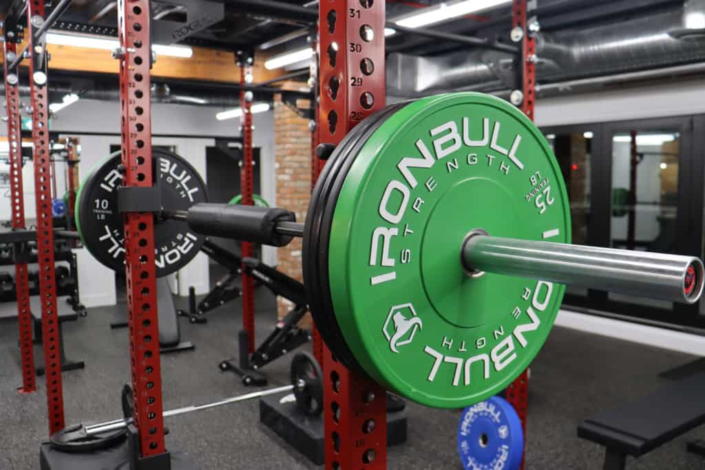 A gym with a green barbell in the middle.