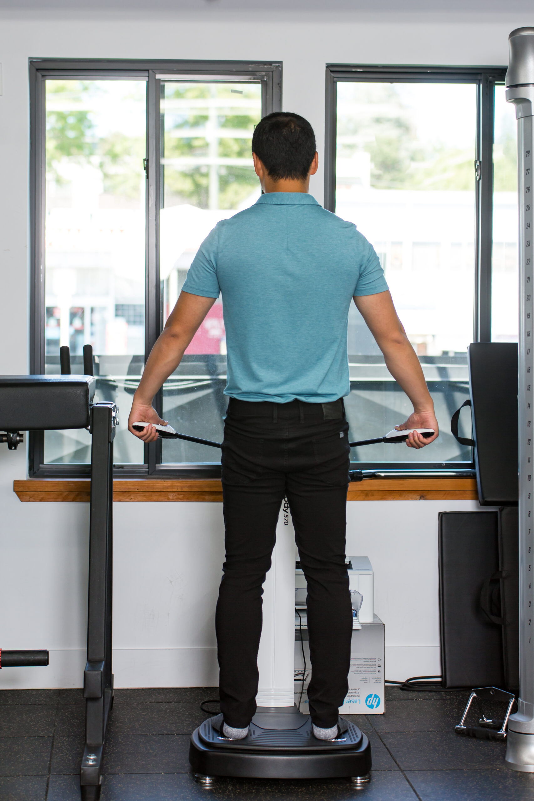 A man standing on an exercise machine in a gym.