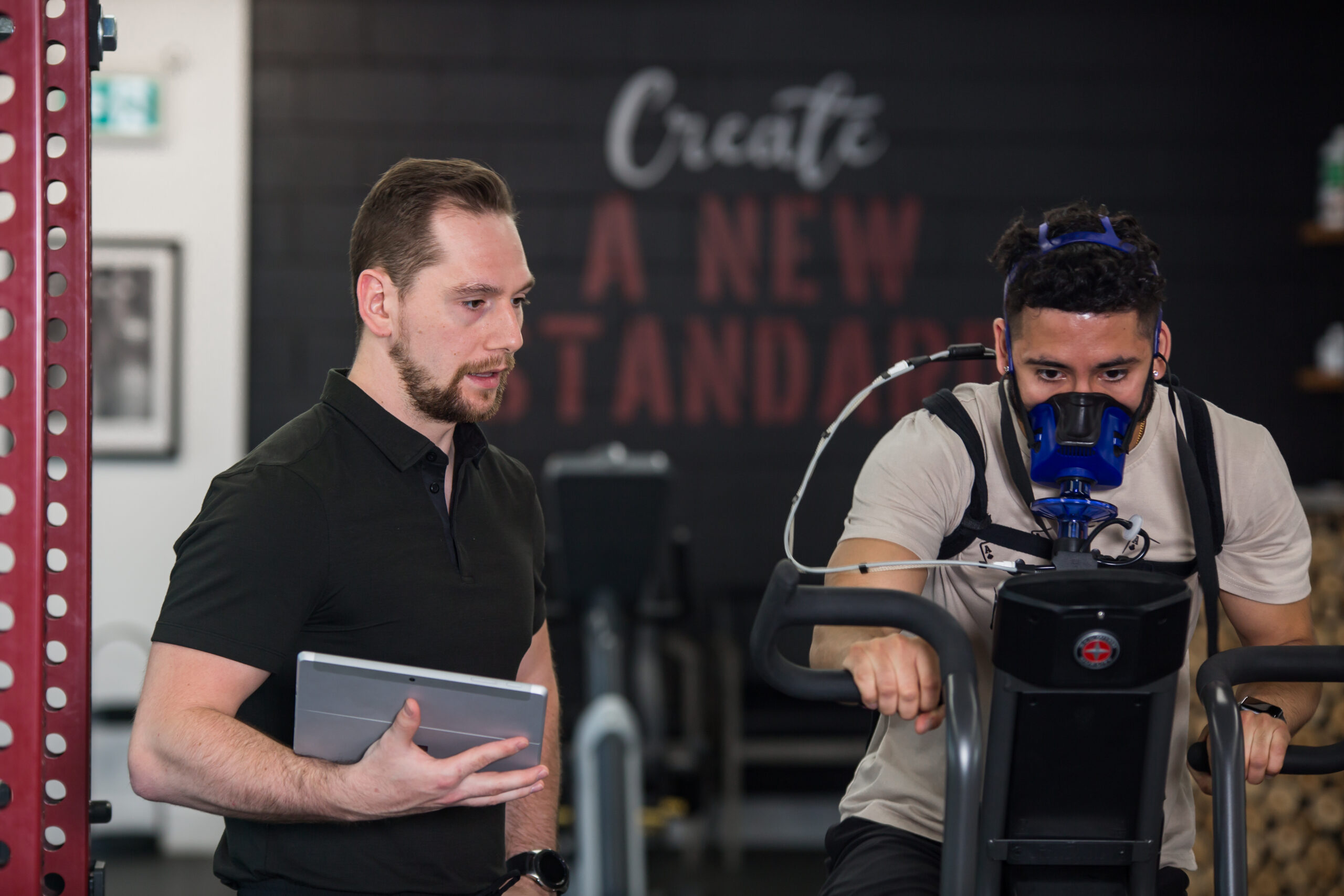 Two men standing next to each other in a gym.