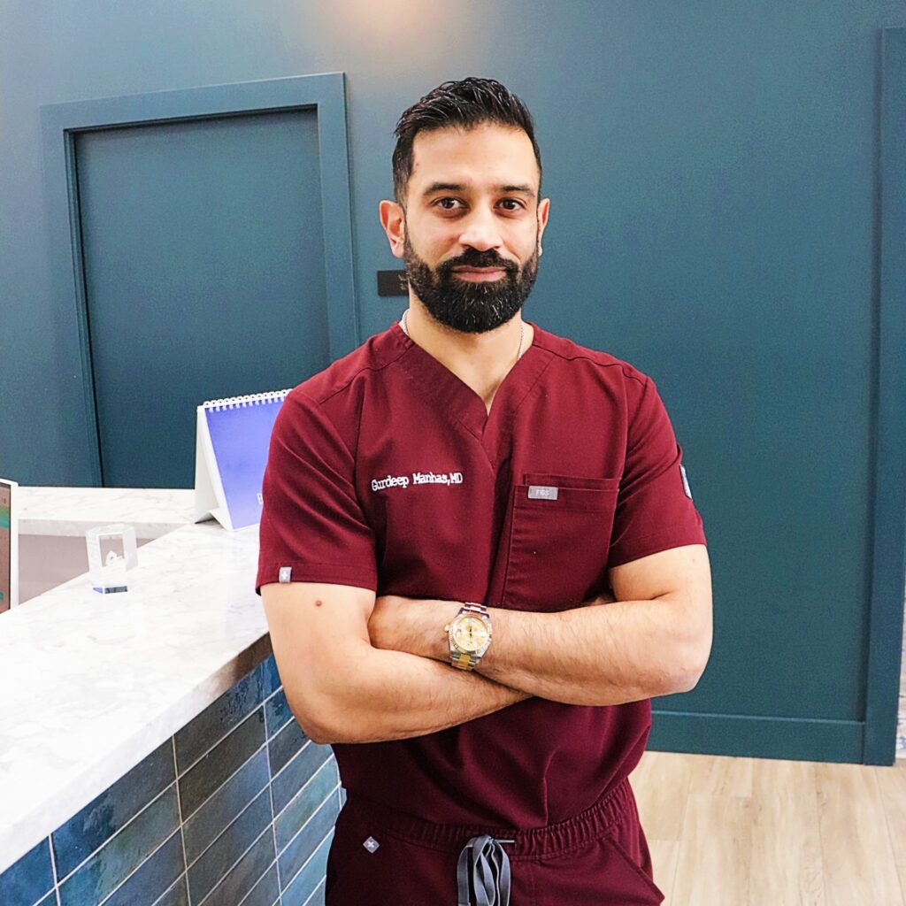 Our Team: A man in scrubs standing in front of a counter.